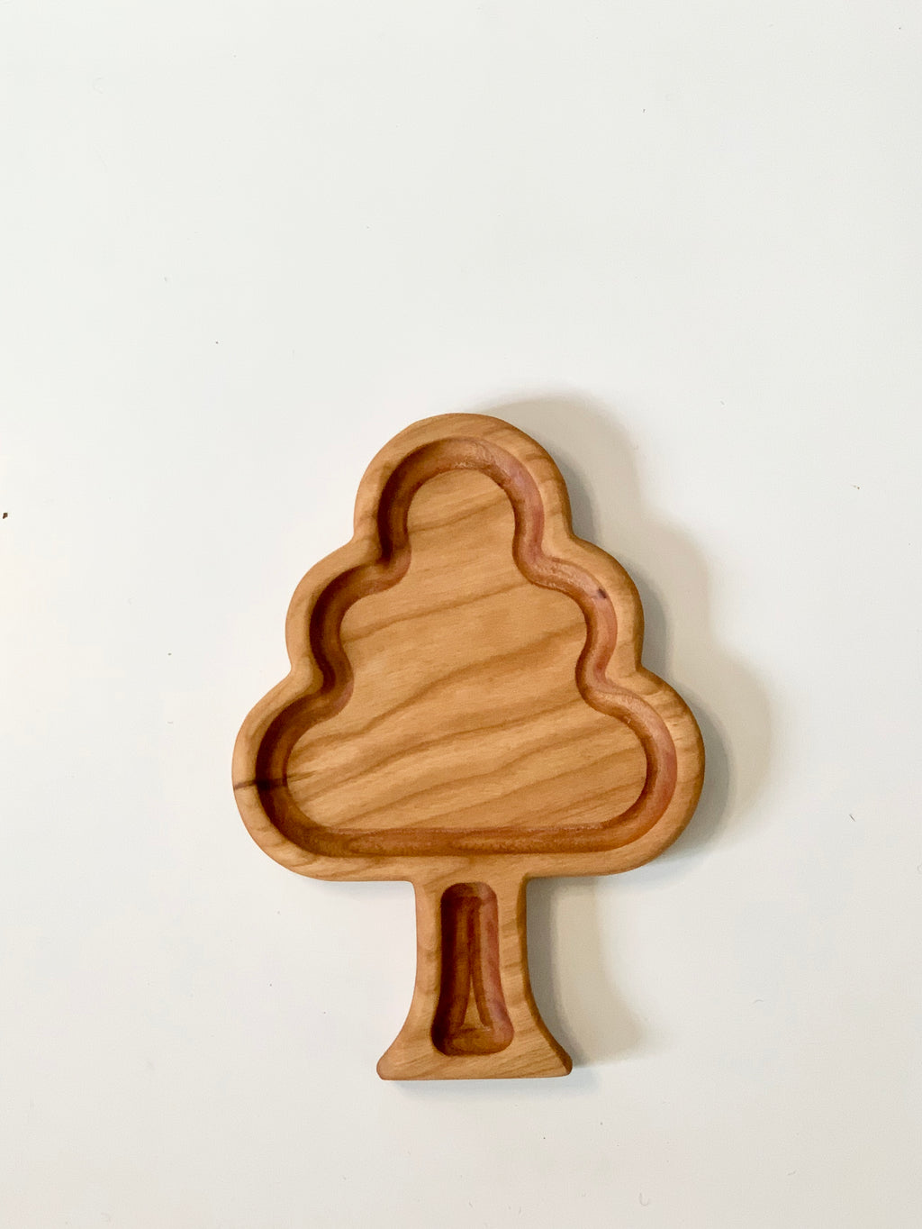 Wooden tree-shaped sensory tray with smooth natural wood grain and carved sections on white background