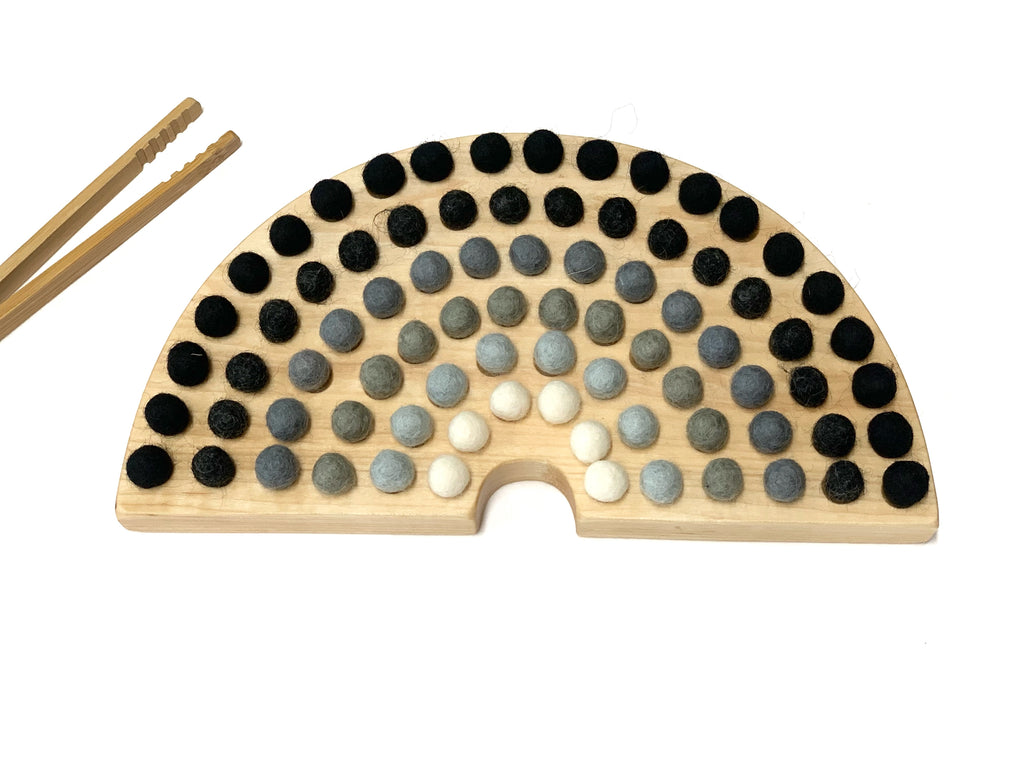 Natural wooden rainbow sorting board with smooth engraved holes and black, gray, and white felt balls with wooden tongs