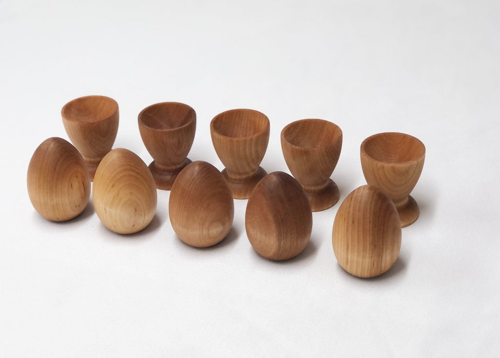 Natural wooden eggs and cups set for Montessori-inspired color sorting and educational play for toddlers.