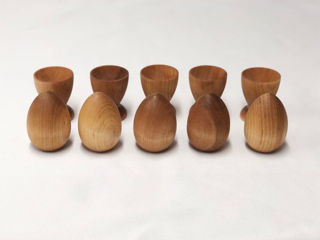 Natural wooden eggs and matching cups set for Montessori-inspired color sorting and educational play for toddlers.