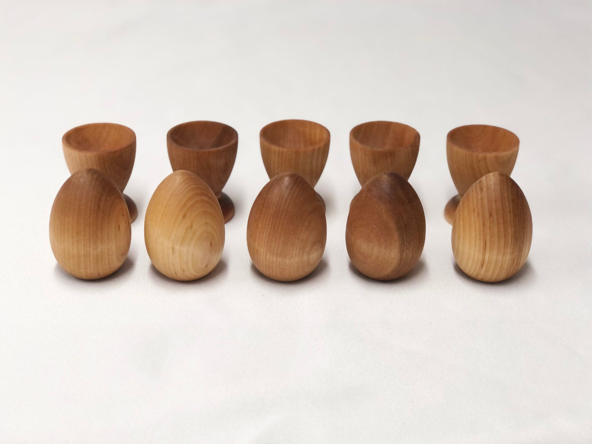 Natural wooden eggs and matching cups set for Montessori-inspired color sorting and educational play for toddlers.
