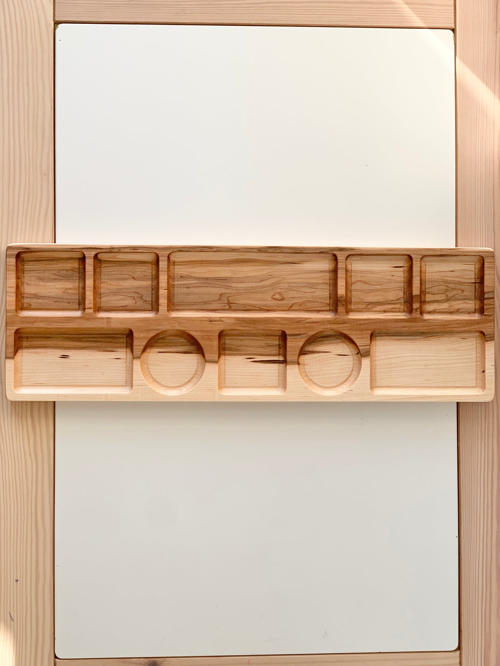 Extra large wooden tinker tray plate with various rectangular and circular compartments on light wood background