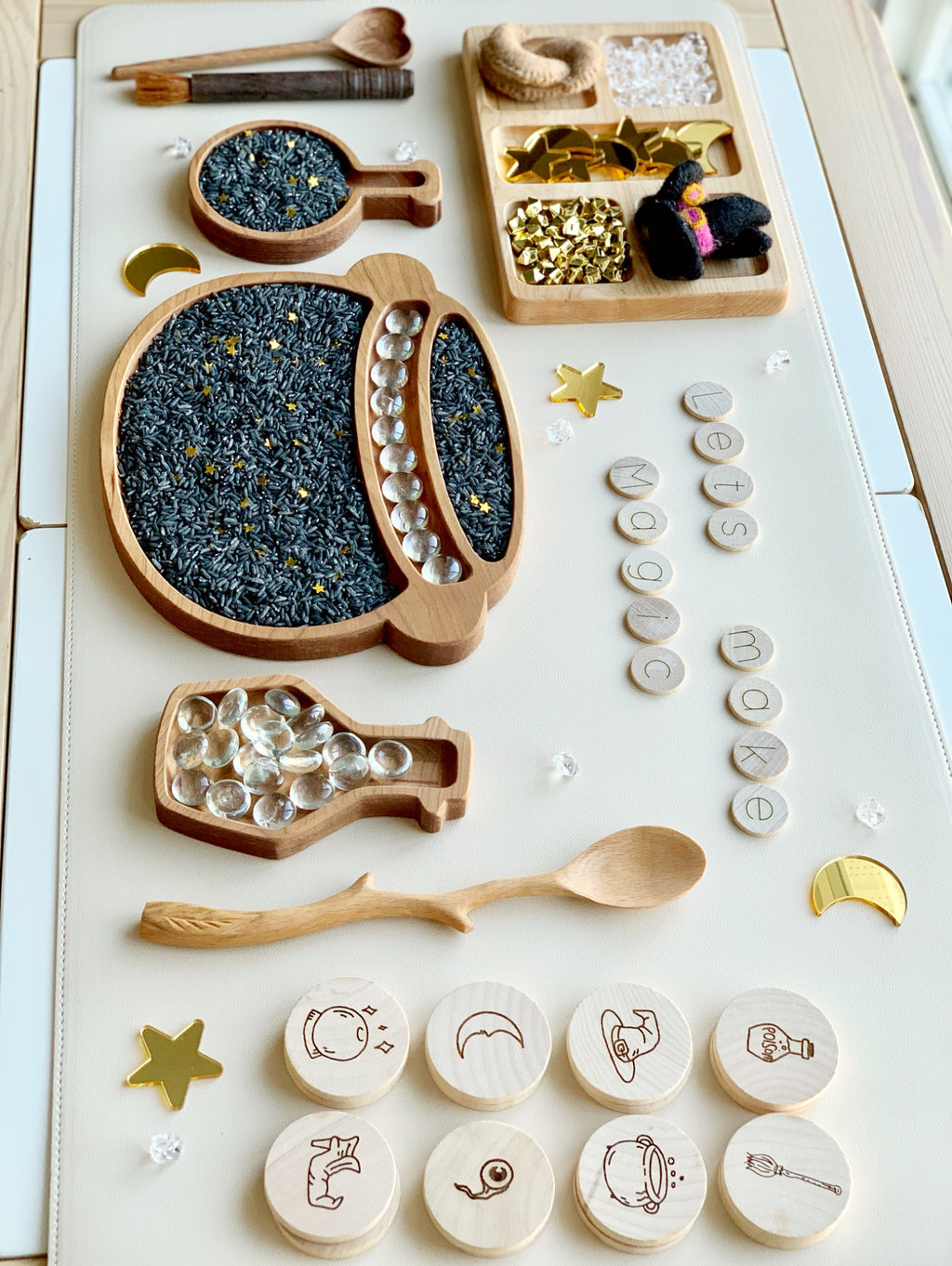 Wooden sensory play tray with gold moons and stars acrylic shapes, black rice, clear beads, and engraved wooden tokens