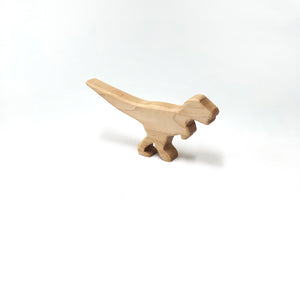 Small natural wooden T Rex dinosaur toy figurine with smooth edges on white background