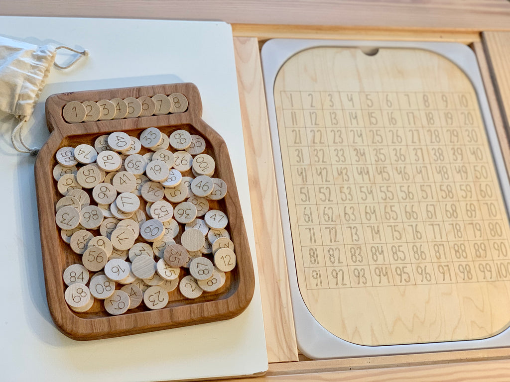 Wooden 100 hundred frame board insert with numbered wooden discs and maple wood tray on light wood surface