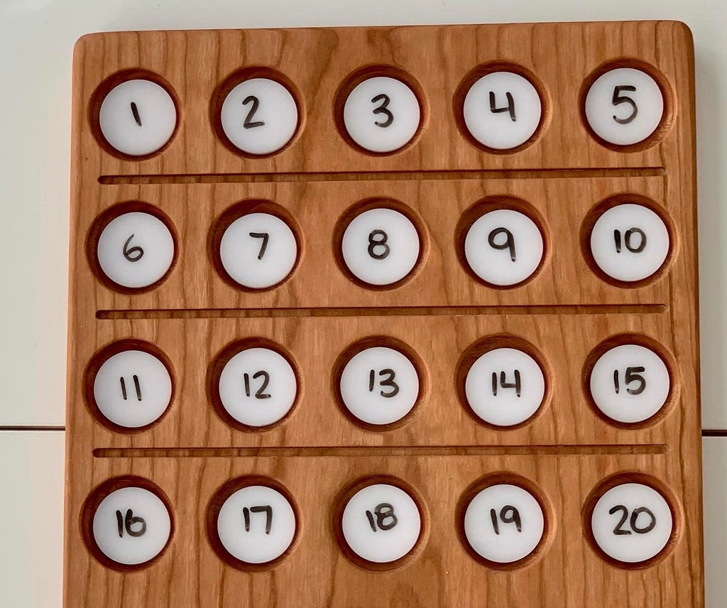 Wooden sensory tray with twenty round white dry erase circles numbered 1 to 20 arranged in rows