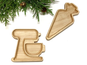 Natural wood sensory trays shaped like a stand mixer and a carrot on white background with pine branches nearby