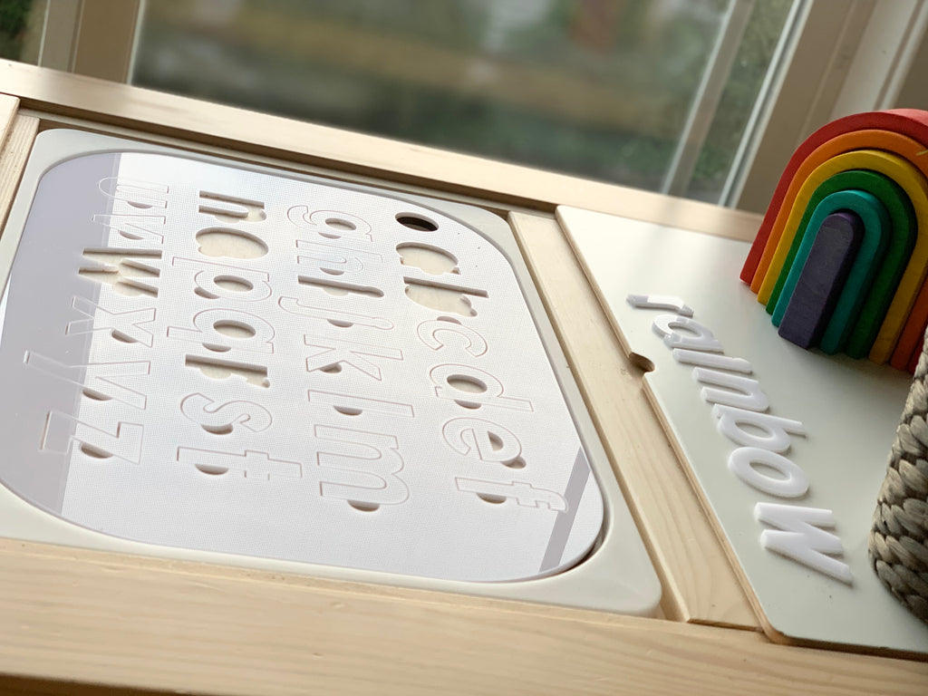 Lowercase alphabet puzzle Flisat table top insert with white acrylic letters and rainbow wooden toy on wooden frame