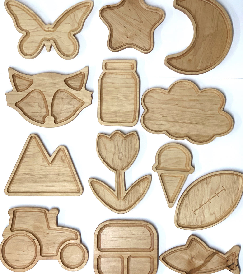 Natural wooden sensory plates shaped like butterfly, star, moon, fox, jar, cloud, mountain, flower, ice cream, tractor, and fish on white background