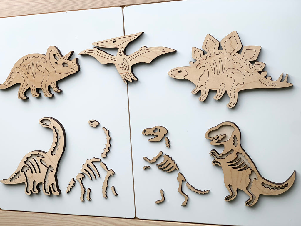 Wooden dinosaur skeleton puzzles including Triceratops, Pterodactyl, Stegosaurus, Brachiosaurus, Velociraptor, and T-Rex on white background