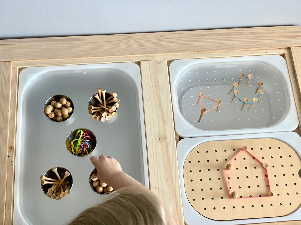 Light maple Tinker Pot Flisat tabletop insert with acrylic cups, metal pegs, and rubber bands for creative play activities