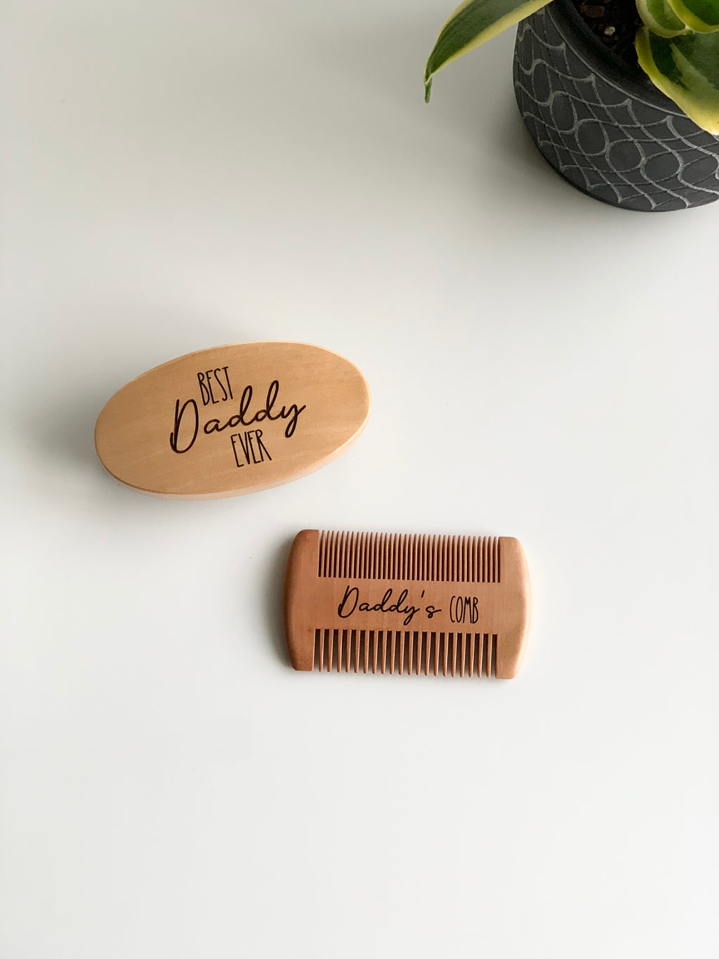 Custom wooden beard brush engraved with Best Daddy Ever and matching comb engraved Daddy’s Comb on white surface