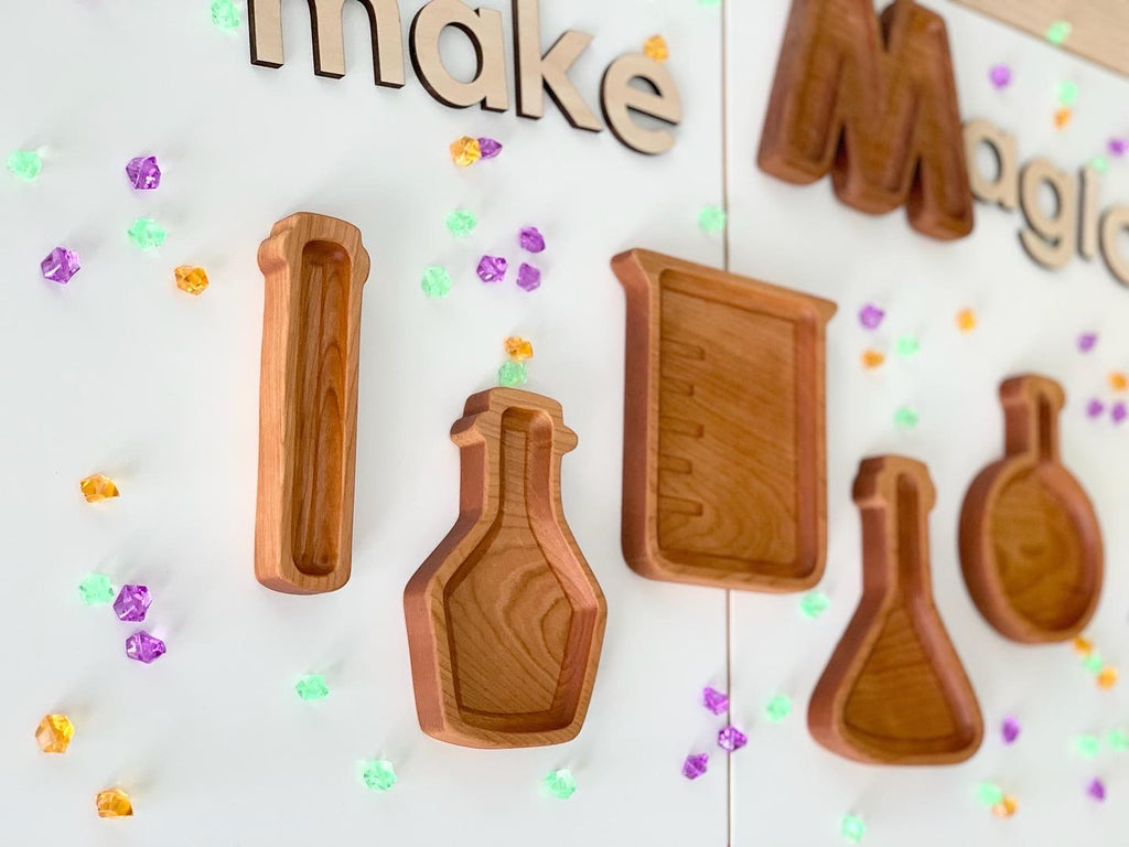 Set of custom wooden sensory trays shaped like science beakers and flasks with natural wood finish on white background