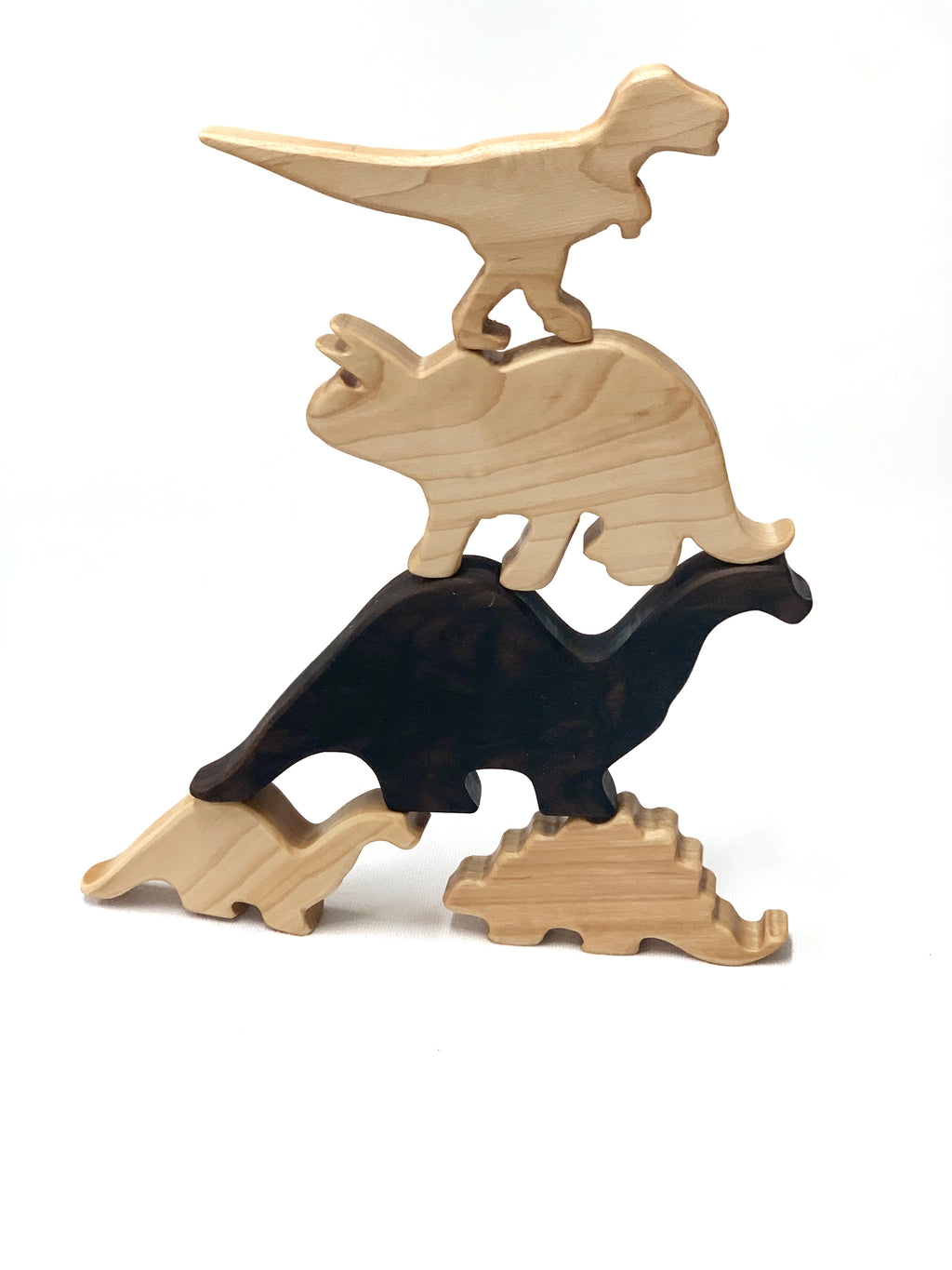 Stacked natural wood dinosaur toy figurines in various shapes and sizes on white background