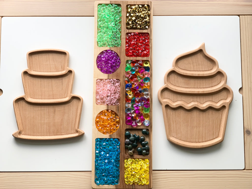 Wooden cupcake plate sensory tray with jewel-like colorful sorting gems on light wood background