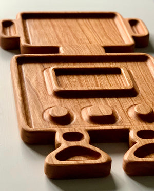 Wooden robot-shaped sensory tray with carved buttons and compartments on light surface