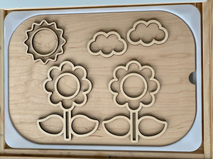Wooden flower-themed fillable Flisat table insert with sun and cloud cutouts on light wood surface