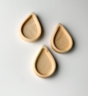 Three natural wooden rain drop shaped plates arranged on white background for sensory play or trays
