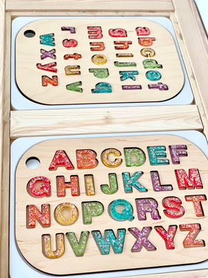 Wooden alphabet puzzle board with colorful resin uppercase and lowercase letters in a Flisat table top insert
