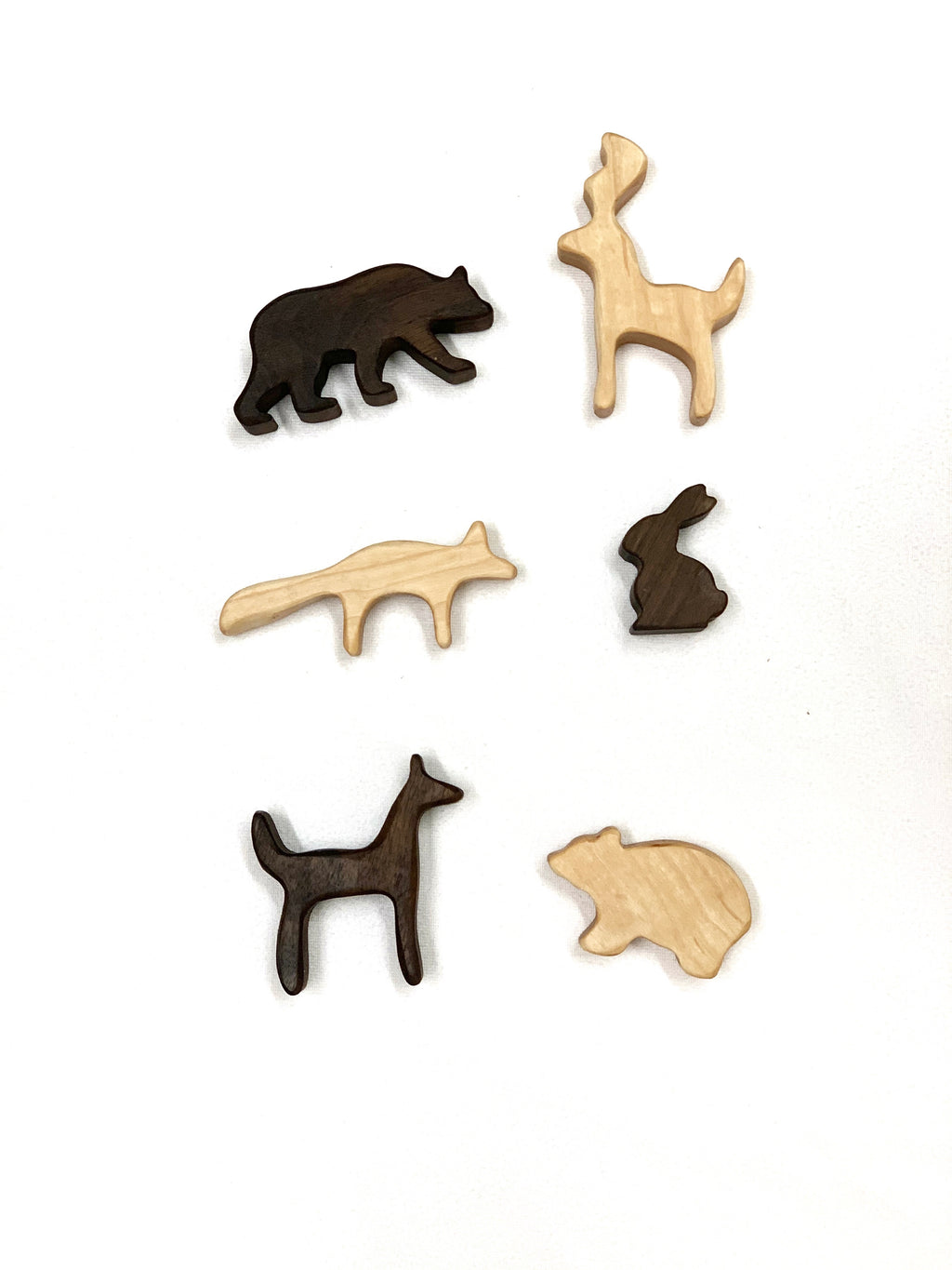 Six small woodland animal wooden toy figurines in natural and dark wood colors on white background