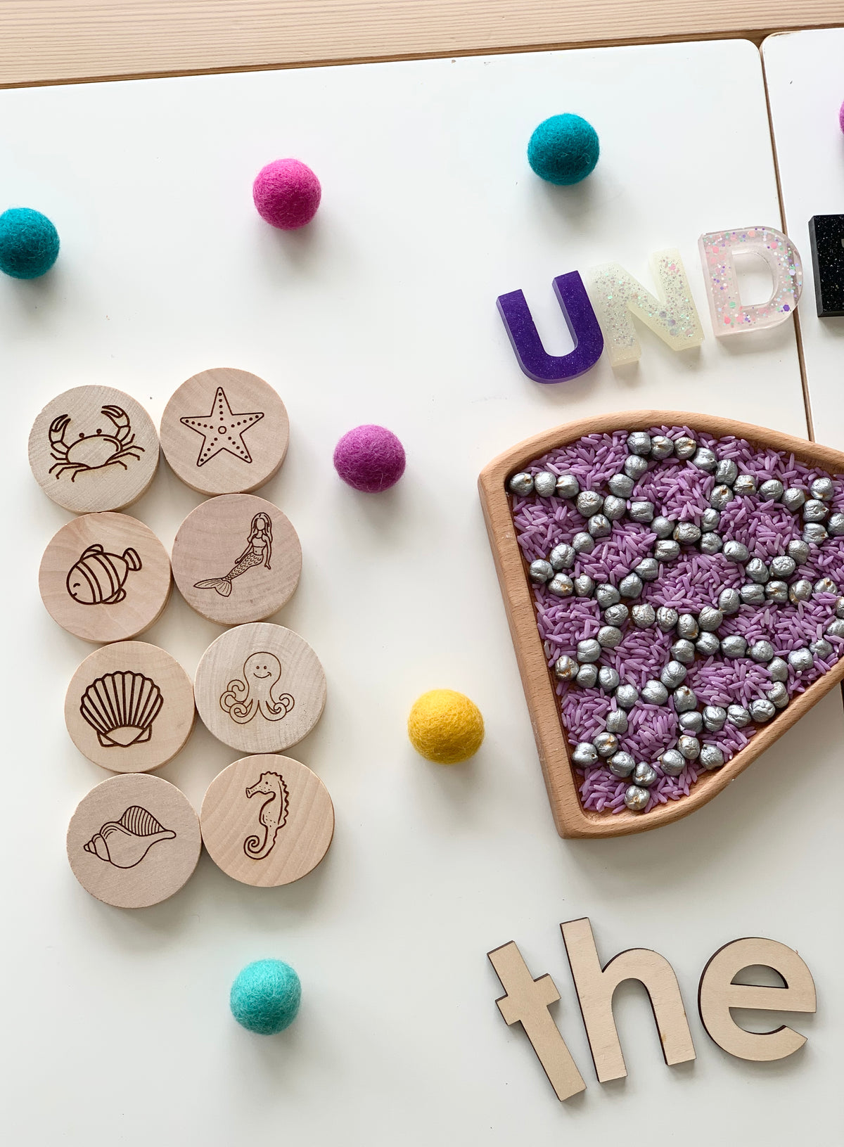 Wooden round memory game discs with engraved sea creatures and a triangle bead and thread pattern piece on white background