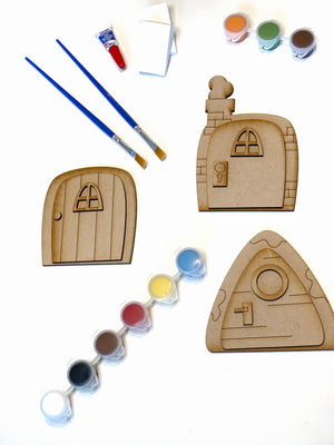 Fairy Doors DIY kit with three unpainted wooden doors, paint pots, two paintbrushes, and glue on white background