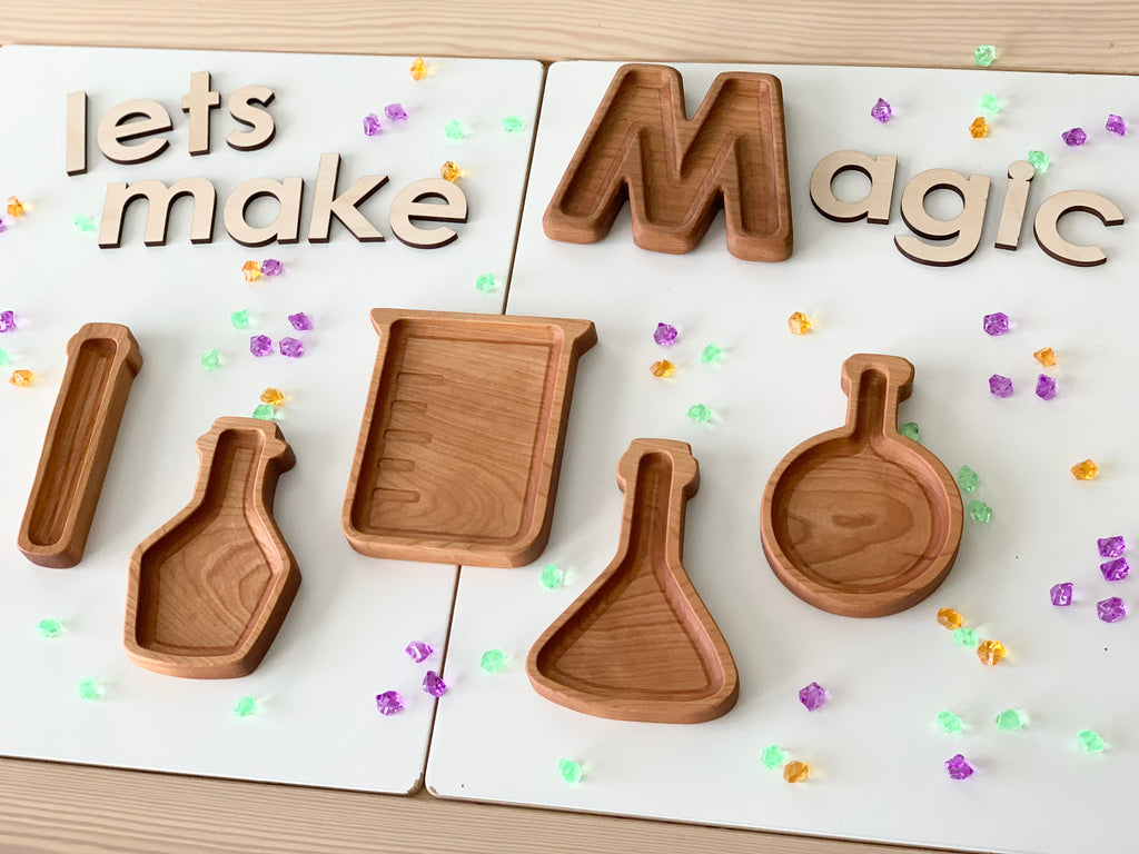 Set of wooden potion bottle plates shaped like science beakers on white surface with scattered colorful beads