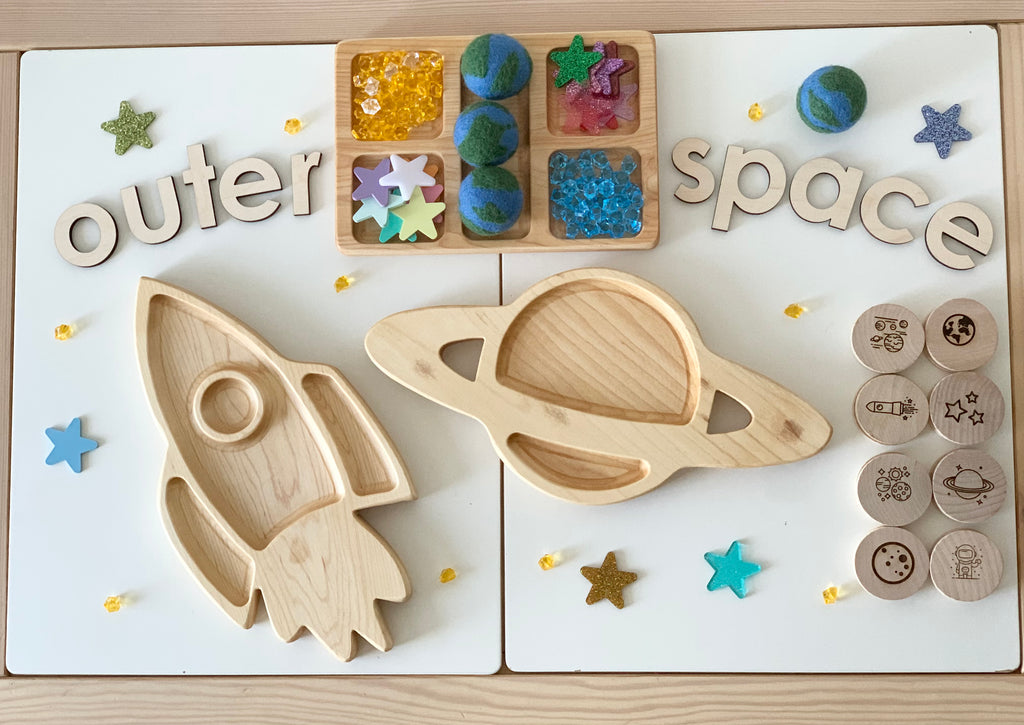 Wooden space-themed memory game with rocket and planet trays, felt planets, star decorations, and engraved wooden discs on white boards