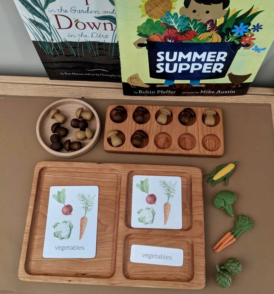 Hardwood three-part card tray with vegetable illustration cards, wooden acorn counters, and miniature vegetable figures on table