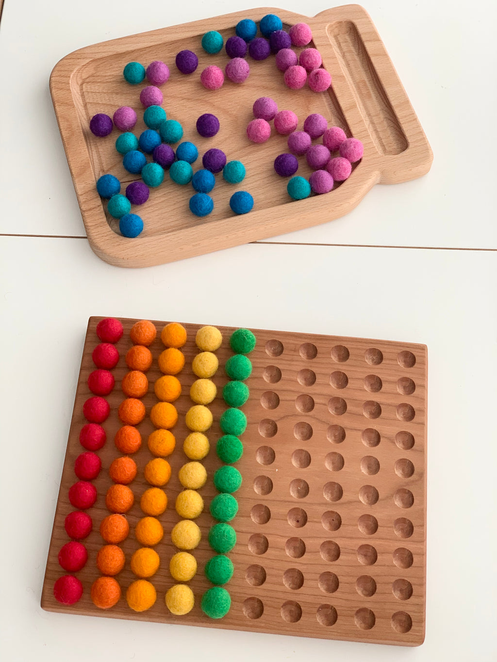 Wooden 100 frame hundred sorting board with colorful felt balls arranged by color on smooth engraved holes