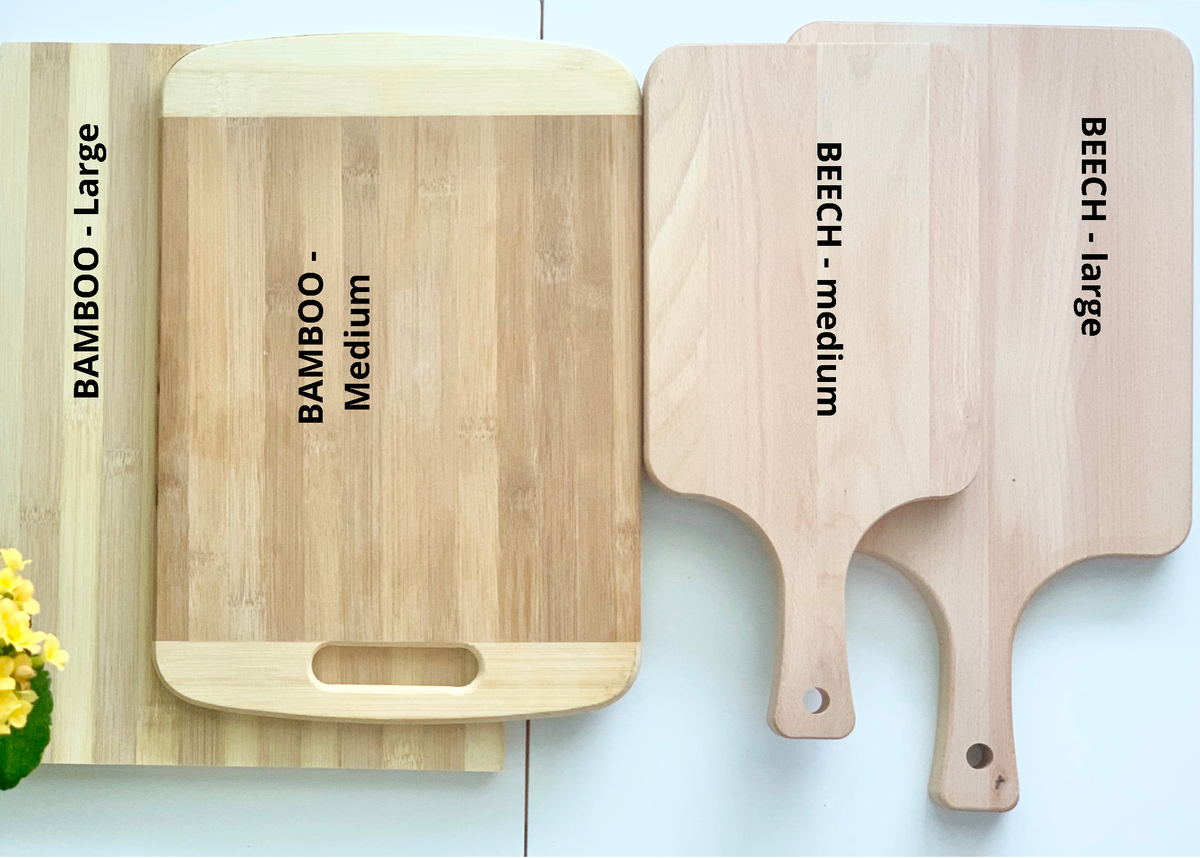 Set of four wooden cutting boards in bamboo and beech wood, varying sizes including large and medium with handles on some boards