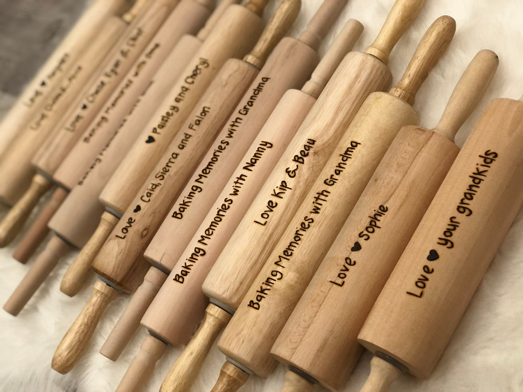 Personalized wooden rolling pins with custom wood burned messages for baking memories and gifts on light wood surfaces