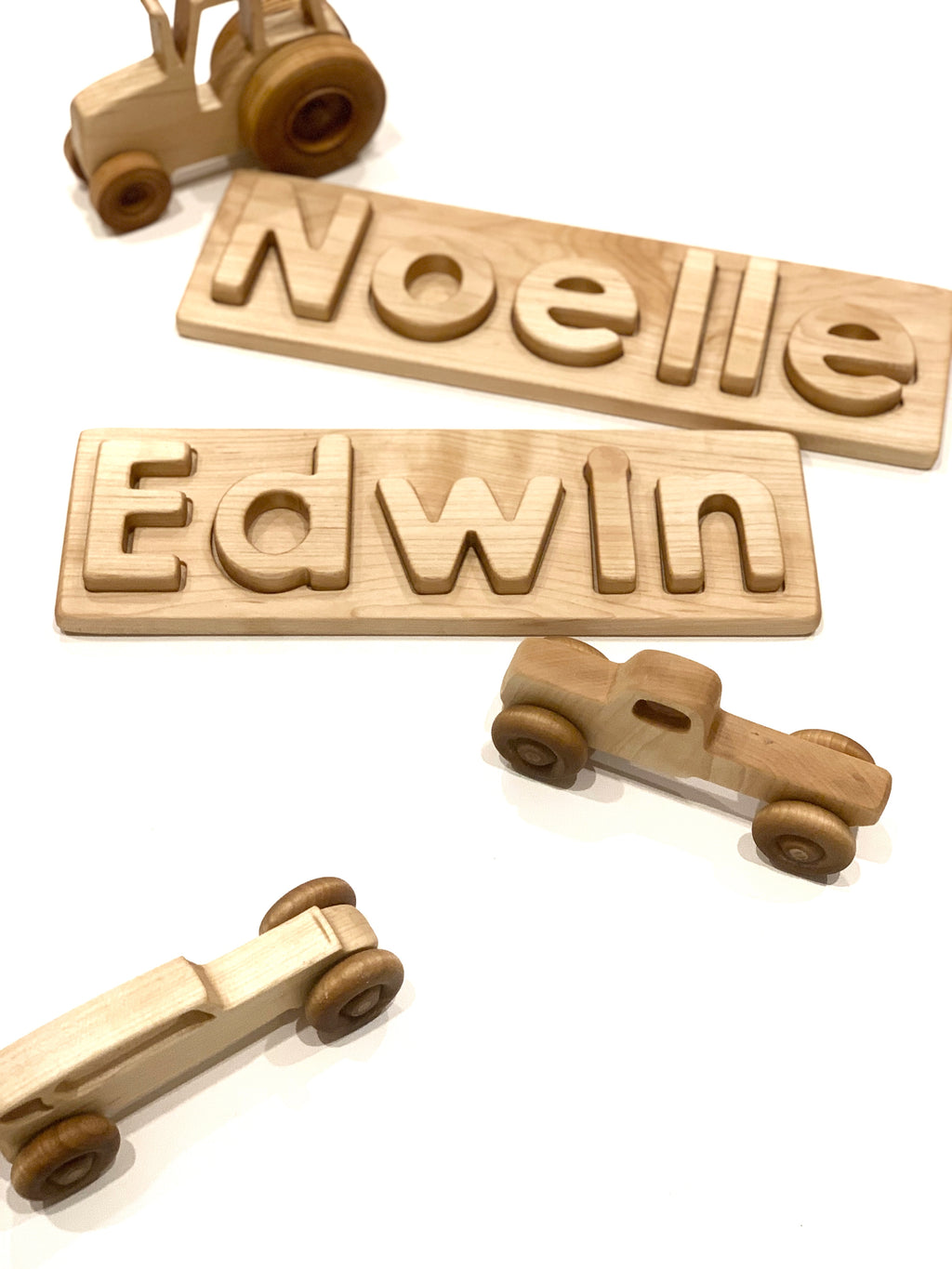 Personalized hardwood name puzzles with uppercase and lowercase letters and wooden toy cars on white background