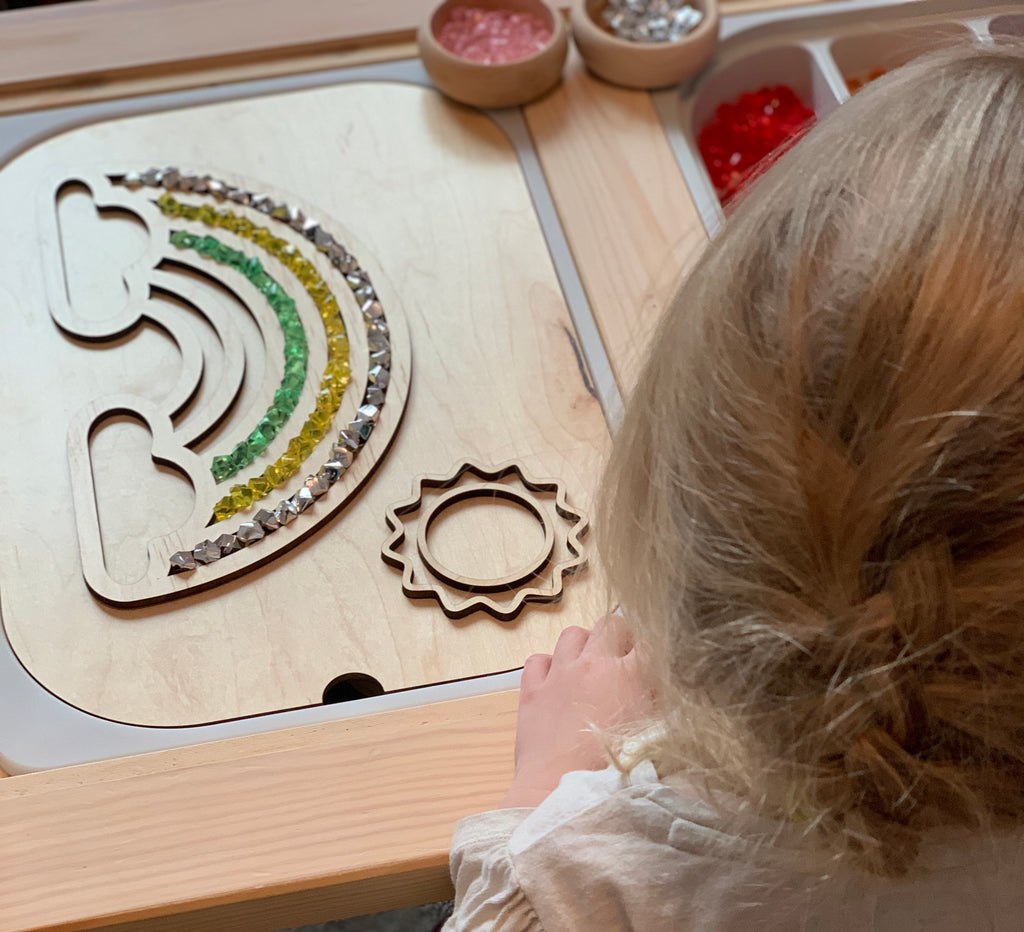 Fillable wooden rainbow Flisat table top insert with colorful acrylic gems and a sun shape on maple plywood surface