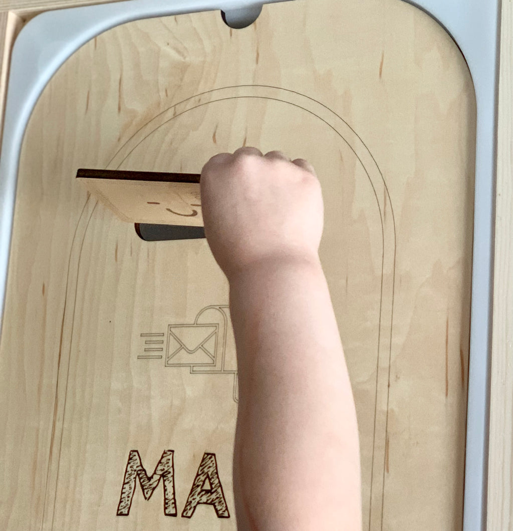 Child’s hand inserting wooden mail into maple plywood mailbox post box Flisat table top insert with engraved details