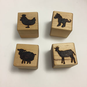 Set of four custom 2-inch wooden blocks engraved with animal silhouettes including chicken, horse, sheep, and goat