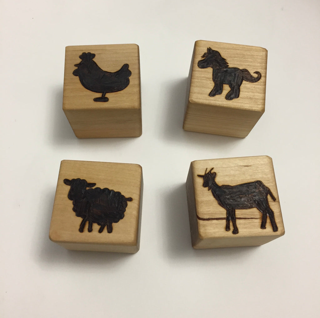 Set of four custom 2-inch wooden blocks engraved with animal silhouettes including chicken, horse, sheep, and goat