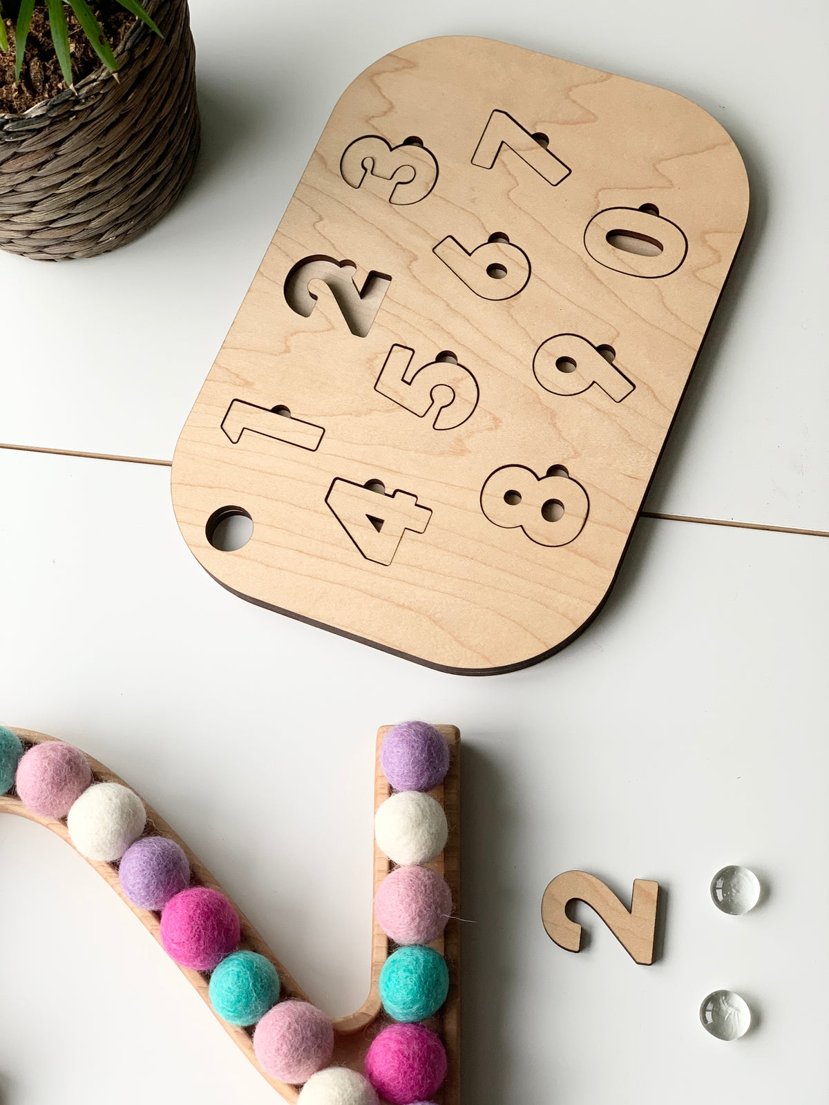 Natural wooden number puzzle Flisat table top insert with cutout numbers 0 to 9 on white surface