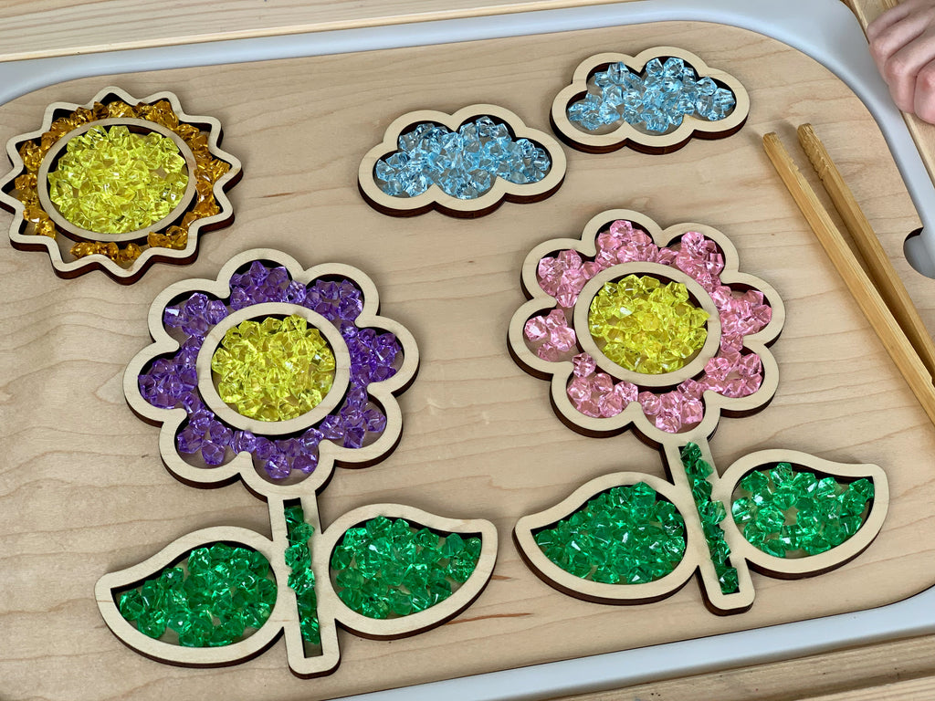 Wooden Flisat table insert with fillable flower, sun, leaf, and cloud shapes containing colorful translucent beads