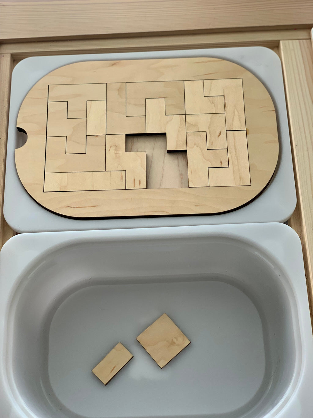 Small wooden puzzle insert for Flisat bin with interlocking geometric pieces and natural wood finish