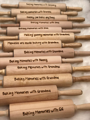 Collection of personalized wooden rolling pins with custom engraved baking messages and names on light wood surface