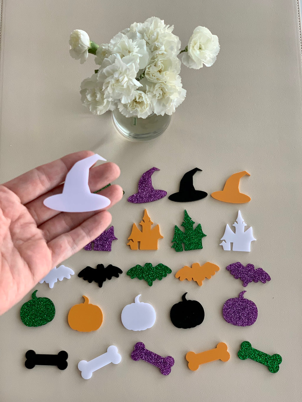 Assorted Halloween acrylic shapes including hats, haunted houses, bats, pumpkins, and bones in various colors with glitter accents