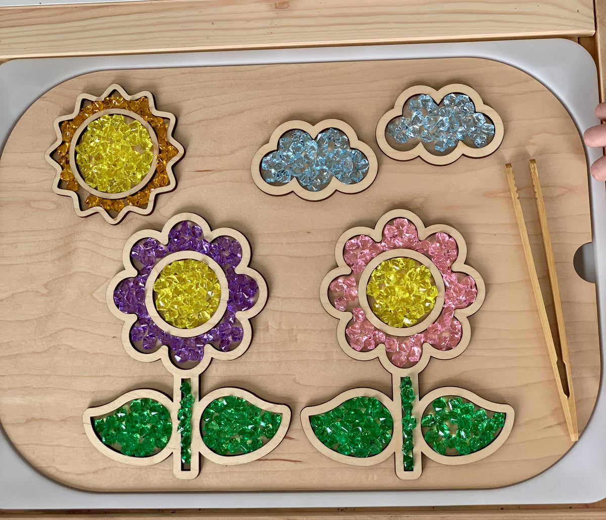 Wooden fillable flower and cloud scene insert with yellow, purple, pink, and blue gel beads and natural wood tweezers