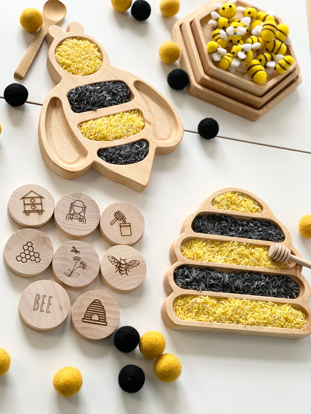 Natural wooden bumble bee and hive sensory trays filled with yellow and black rice with honeycomb and bee engraved wooden tokens