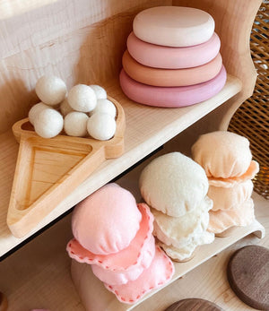 Wooden ice cream cone tray with white felt balls and pastel felt ice cream scoops on wooden shelves