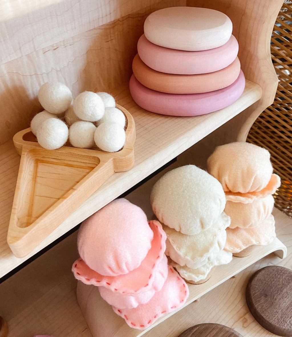 Wooden ice cream cone tray with white felt balls and pastel felt ice cream scoops on wooden shelves