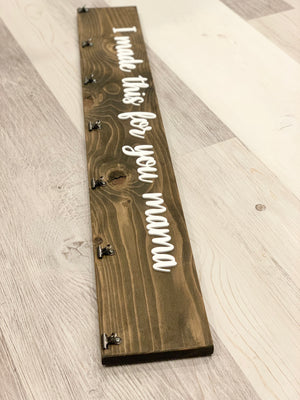 Long custom wooden sign with white cursive letters reading I made this for you mama on dark stained wood with metal clips