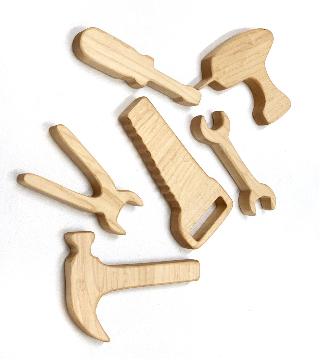 Set of six natural wooden toy tools including hammer, saw, wrench, pliers, screwdriver, and drill on white background