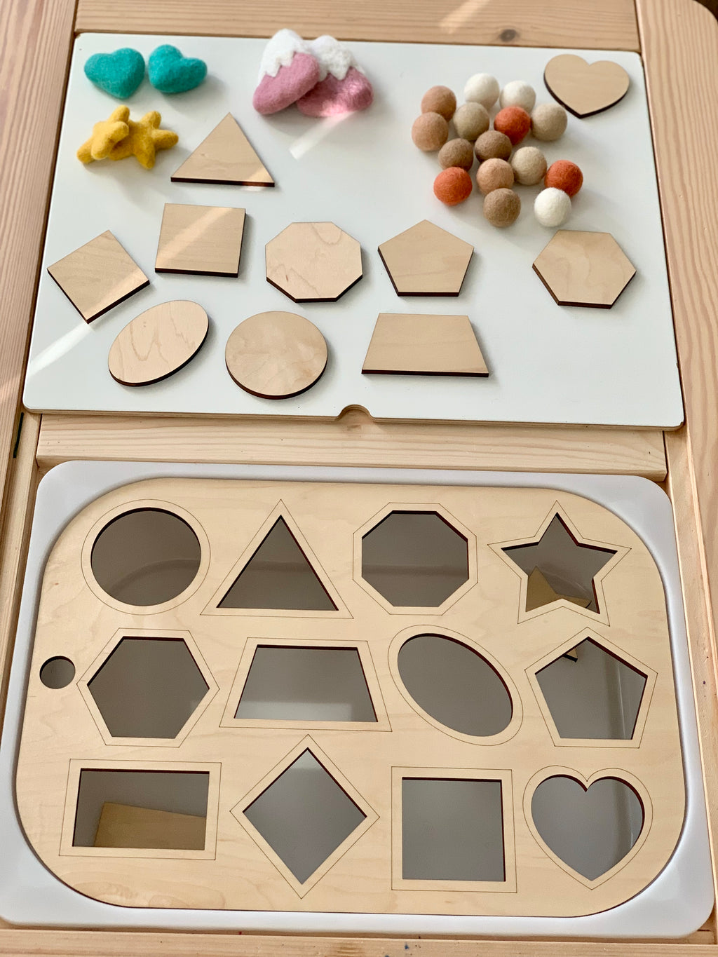 Wooden shape sorter Flisat table top insert with matching geometric pieces on light wood bin surface