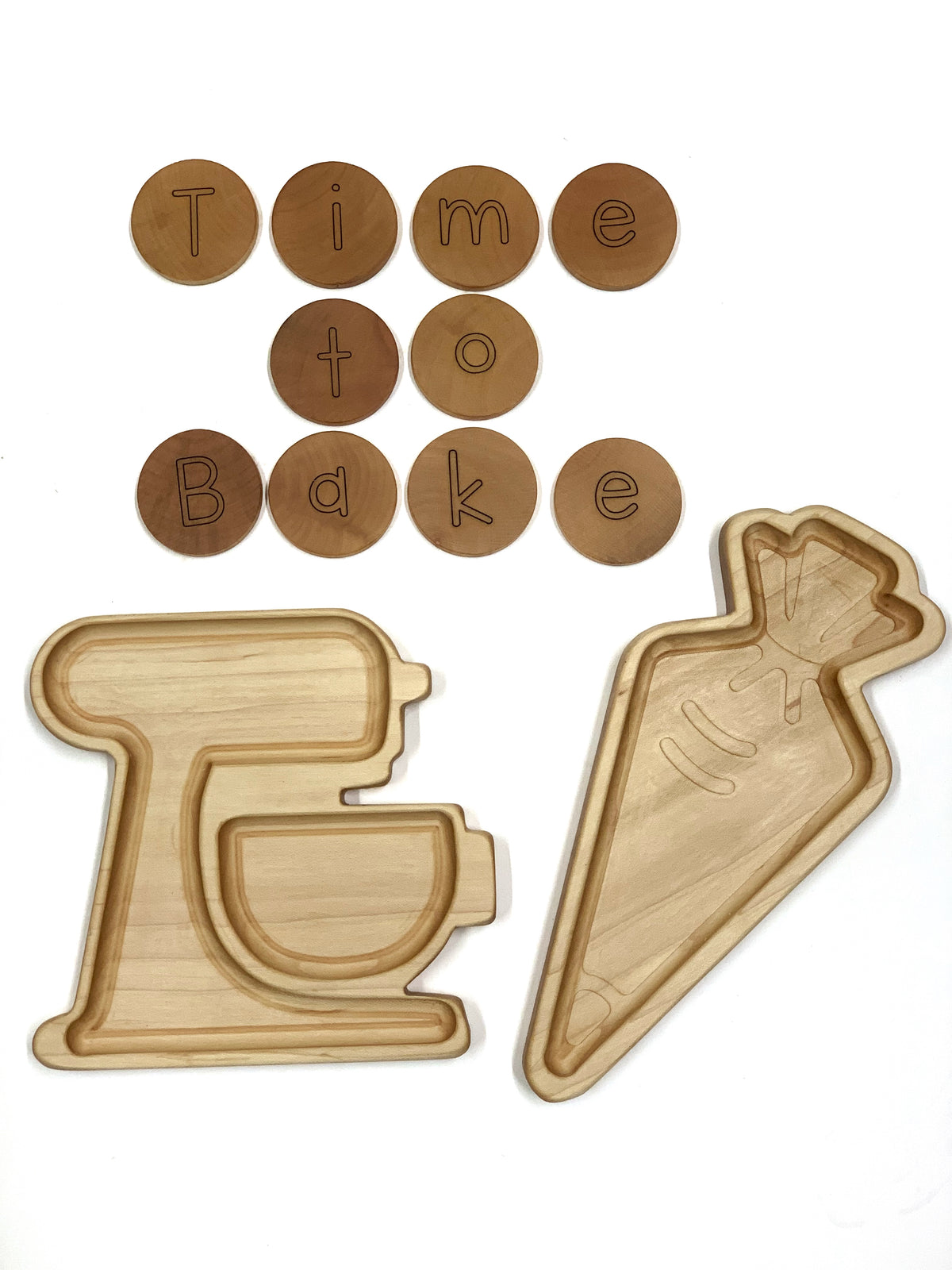 Natural wooden carrot-shaped plate and mixer-shaped tray with round wooden letter discs spelling Time to Bake on white background
